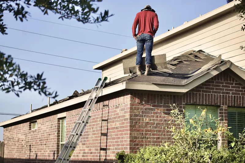 Professional roofer working on a residential roof in Har Val Manor